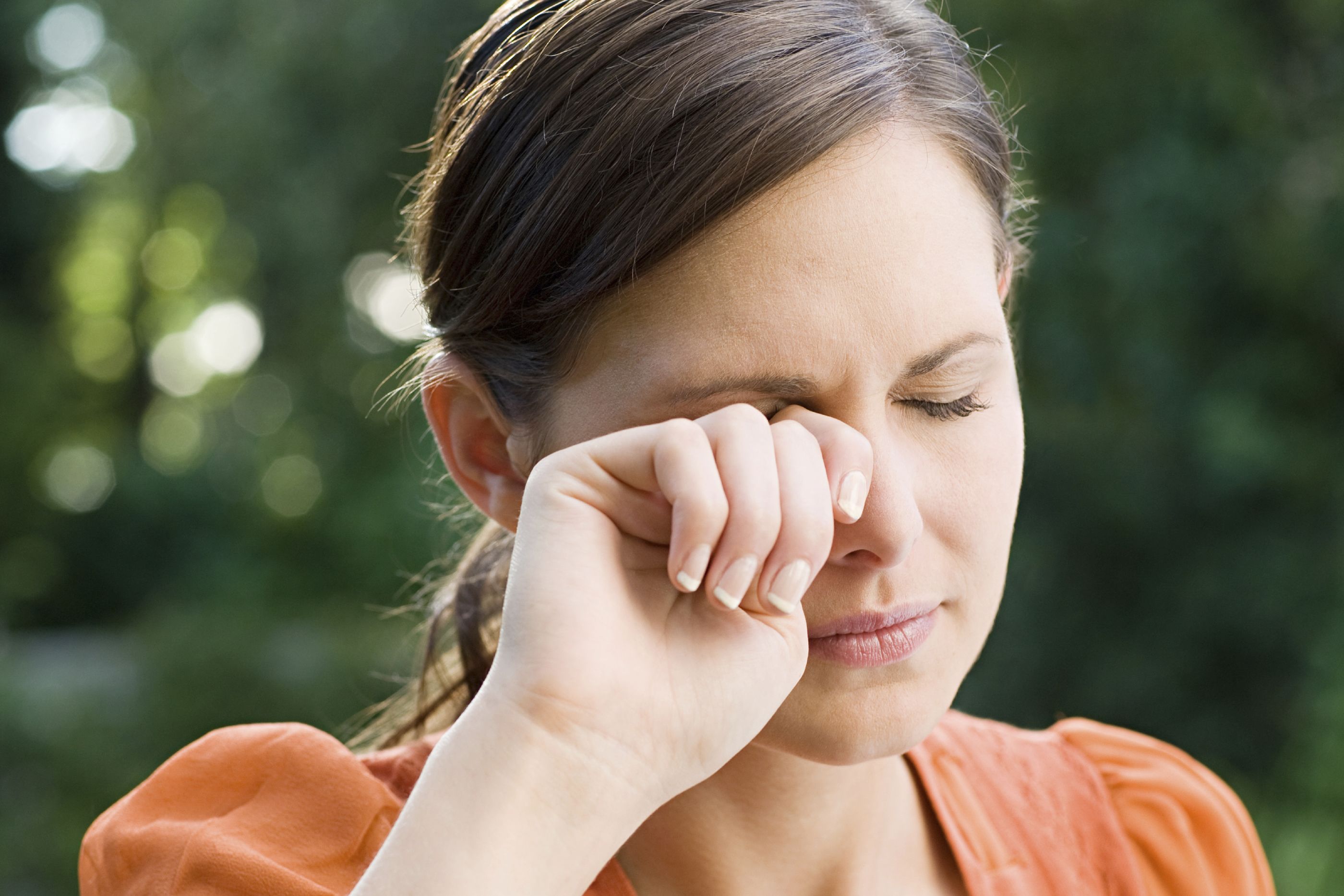 woman rubbing her eyes