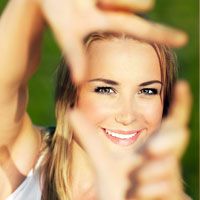 Pretty young blond making frame out of hands in front of face